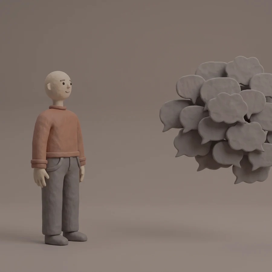 A clay figure standing a step back from a clump of thought bubbles, watching it with a faint smile