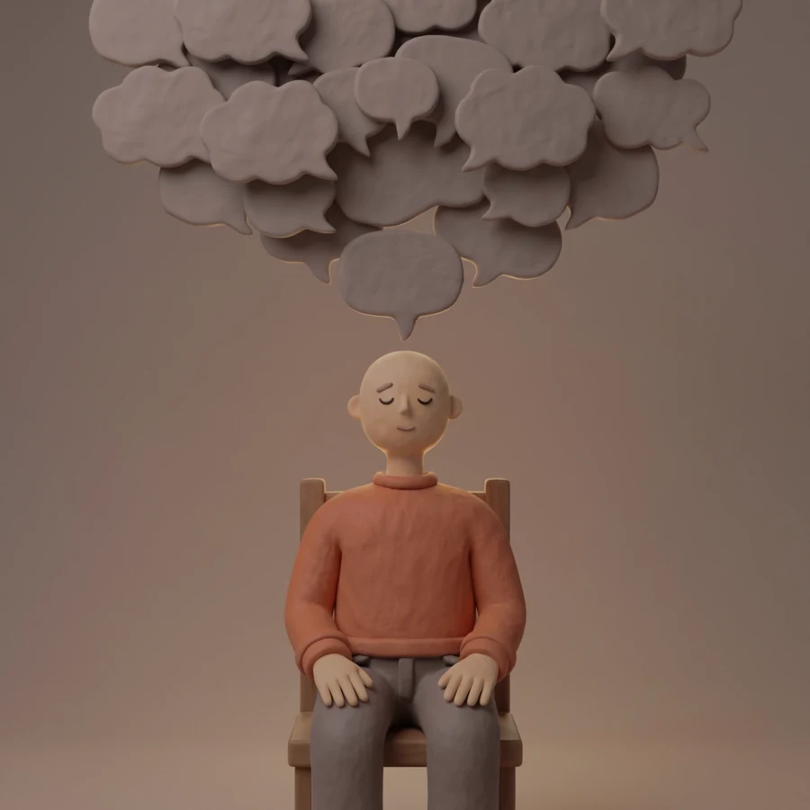 A clay figure meditating with his eyes closed on a chair, unaware of the thought bubbles piling up above his head